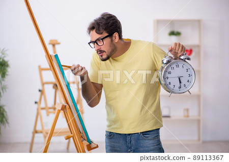 Young man enjoying painting at home 89113367