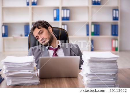 Young male employee and too much work in the office 89113622