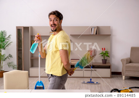 Young man doing housework at home Young man doing housework at home 89114485