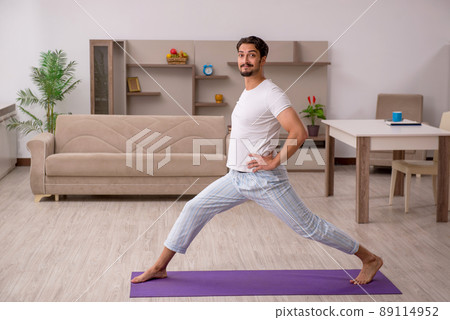 Young man doing sport exercises at home 89114952