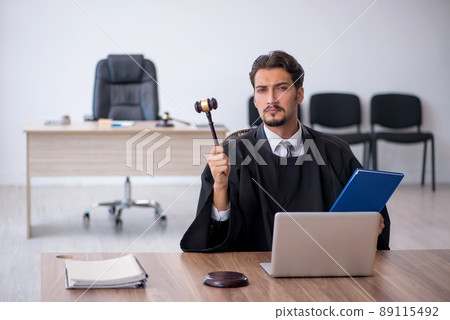 Young male judge working in the courthouse 89115492