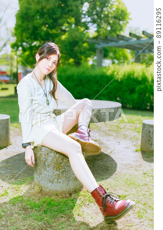 A beautiful older sister who enjoys a walk in a beautiful park with fresh green in the cheerful early summer A beautiful older sister who enjoys a walk in a beautiful park with fresh green in the cheerful early summer 89116295