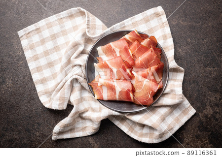 Sliced schwarzwald ham. Dried prosciutto ham on plate. 89116361