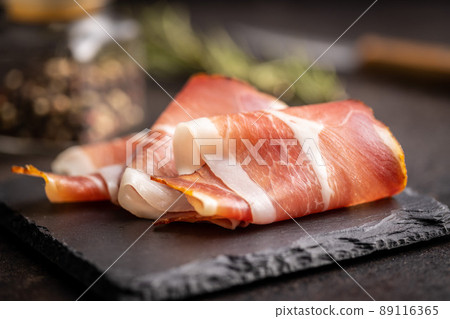 Sliced schwarzwald ham. Dried prosciutto ham on cutting board. 89116365