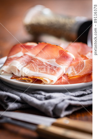 Sliced schwarzwald ham. Dried prosciutto ham on plate. 89116378