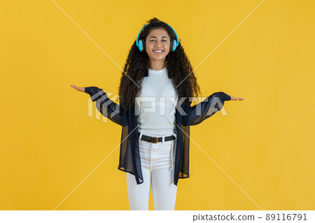 Young woman with her palms facing up on yellow background Young woman with her palms facing up on yellow background 89116791