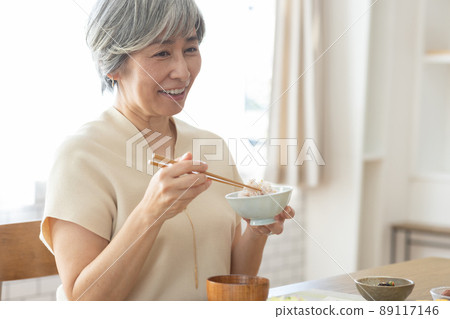 一個 50 多歲的微笑女人吃早餐 89117146