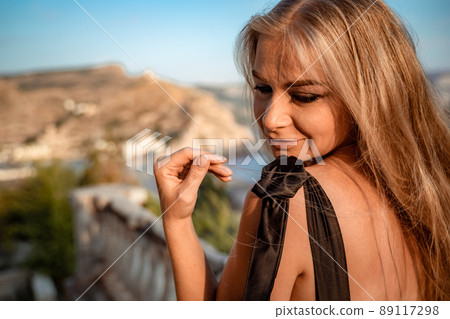 Blonde long hair, nature summer happy adult girl with long blond hair developing in the wind in nature. Dressed in a black top, white skirt. Blonde long hair, nature summer happy adult girl with long blond hair developing in the wind in nature. Dressed in a black top, white skirt. 89117298
