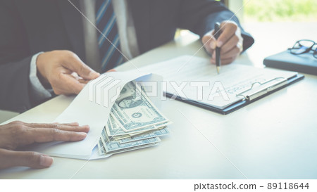 Businessman giving money while making deal to agreement a real estate contract and financial corporate.Bribe and corruption concept Businessman giving money while making deal to agreement a real estate contract and financial corporate.Bribe and corruption concept 89118644