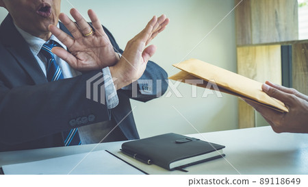 Businessman refusing money in the envelope to agreement contract, Bribe and corruption concept 89118649