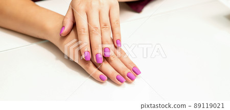 Beautiful manicure with purple, pink nail polish on young caucasian female hands Beautiful manicure with purple, pink nail polish on young caucasian female hands 89119021