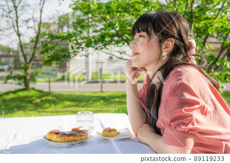 Woman eating homemade cheesecake outdoors 89119233