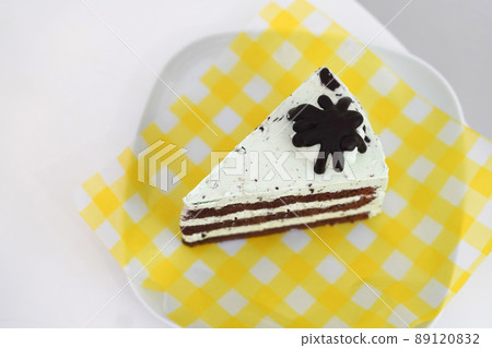 closeup chocolate peppermint cake, placed on a yellow and white plastic plate on a white ceramic plate, white background 89120832