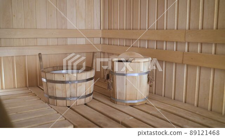 Spa concept of traditional old Russian sauna. Interior details Finnish sauna steam bath with traditional sauna accessories. Wooden basin in the interior of the sauna. Spa concept of traditional old Russian sauna. Interior details Finnish sauna steam bath with traditional sauna accessories. Wooden basin in the interior of the sauna. 89121468