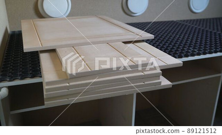 Wooden parts or panels. A stack of wood sheets for furniture production are on the workbench. A stack of chipboard sheets in the furniture industry. Wooden parts or panels. A stack of wood sheets for furniture production are on the workbench. A stack of chipboard sheets in the furniture industry. 89121512