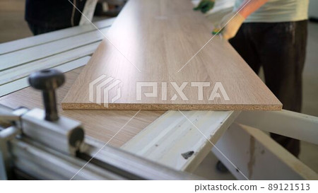 Tree design concept. Workers sawing a wooden panel at a furniture factory. Tree design concept. Workers sawing a wooden panel at a furniture factory. 89121513