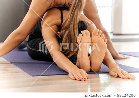 Omen doing stretching on mat in yoga class laying on one another 89124296