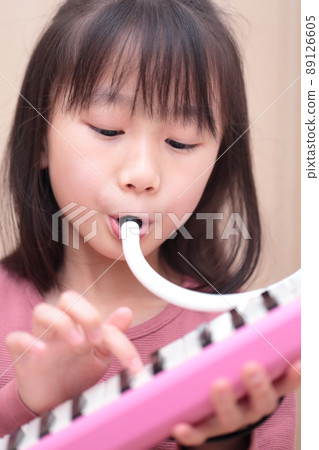 Girl playing keyboard harmonica 89126605