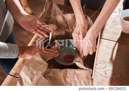 Two women putting new hand made plate at the paper and cupboard box Two women putting new hand made plate at the paper and cupboard box 89126632