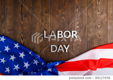 words labor day laid with silver metal letters on wooden surface with crumpled USA flag on bottom side words labor day laid with silver metal letters on wooden surface with crumpled USA flag on bottom side 89127456