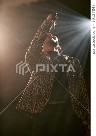 Bearded man in a leopard print jacket singing enthusiastically Bearded man in a leopard print jacket singing enthusiastically 89127848
