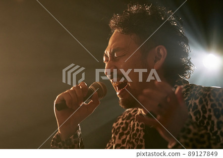 Bearded man in a leopard print jacket singing enthusiastically Bearded man in a leopard print jacket singing enthusiastically 89127849