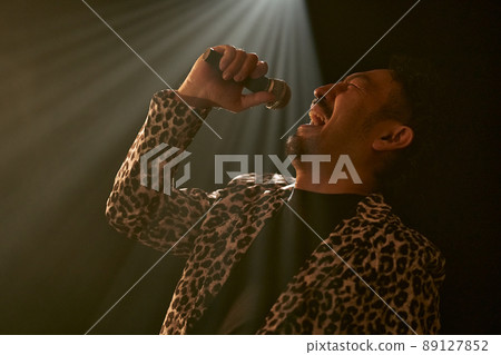 Bearded man in a leopard print jacket singing enthusiastically Bearded man in a leopard print jacket singing enthusiastically 89127852