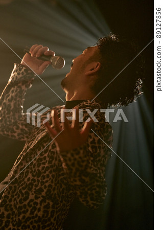 Bearded man in a leopard print jacket singing enthusiastically Bearded man in a leopard print jacket singing enthusiastically 89127856