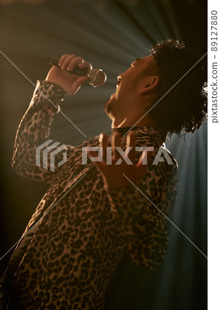 Bearded man in a leopard print jacket singing enthusiastically Bearded man in a leopard print jacket singing enthusiastically 89127880