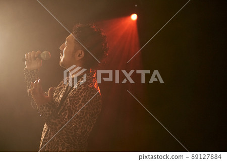 Bearded man in a leopard print jacket singing enthusiastically Bearded man in a leopard print jacket singing enthusiastically 89127884