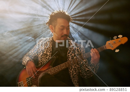 Bearded man in a leopard print jacket playing the base 89128851