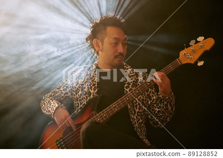 Bearded man in a leopard print jacket playing the base Bearded man in a leopard print jacket playing the base 89128852