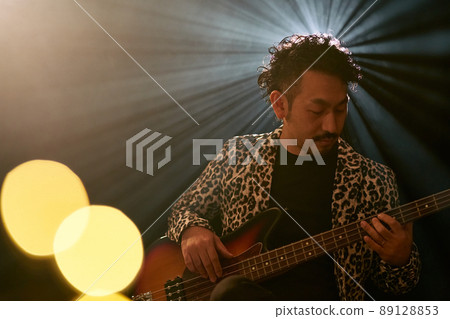 Bearded man in a leopard print jacket playing the base Bearded man in a leopard print jacket playing the base 89128853