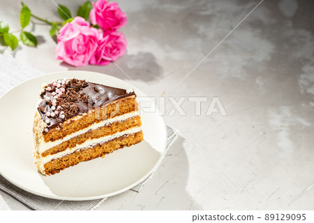 Layered cake with pink roses over grey background 89129095