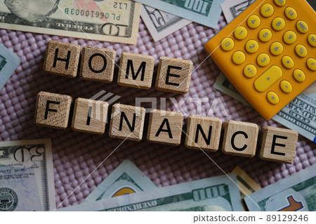 Dollar bills and calculator lying near wooden cubes with words home finance closeup Dollar bills and calculator lying near wooden cubes with words home finance closeup 89129246