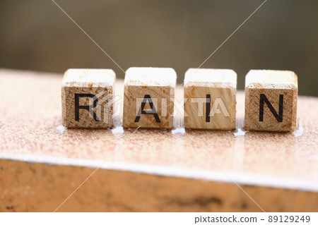 Wooden cubes with words rain lying on wet windowsill closeup Wooden cubes with words rain lying on wet windowsill closeup 89129249
