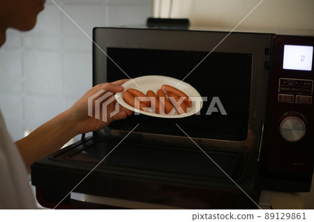 A man who arranges wieners on a paper plate and tries to heat them in the microwave A man who arranges wieners on a paper plate and tries to heat them in the microwave 89129861