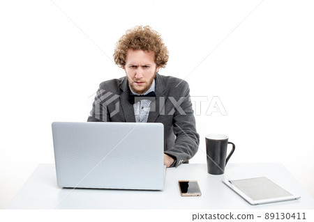 Businessman looking at his Laptop, huge cup of coffee Businessman looking at his Laptop, huge cup of coffee 89130411