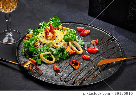 Asian style salad of greens with fried squid, shrimps, mussels and pineapple Asian style salad of greens with fried squid, shrimps, mussels and pineapple 89130910