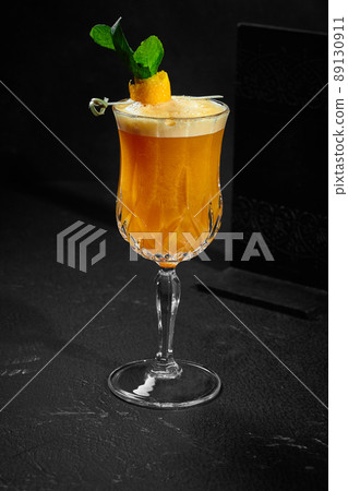 Refreshing orangeade with fresh mint in glass on black background Refreshing orangeade with fresh mint in glass on black background 89130911