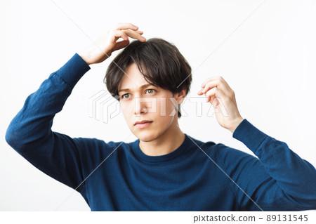 A man fixing his hair 89131545
