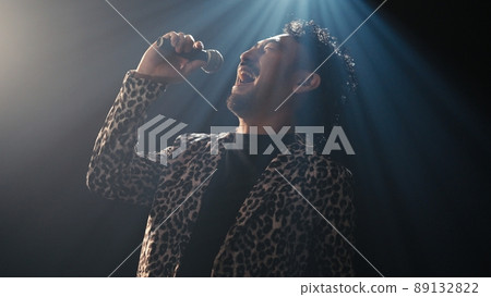 Bearded man in a leopard print jacket singing enthusiastically 89132822