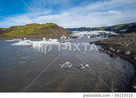 Skaftafellsjokull glacier, Iceland. Glacier tongue slides from the Vatnajokull icecap or Vatna Glacier near subglacial Esjufjoll volcano. Glacial lagoon with blocks of ice and surrounding mountains. 89133518