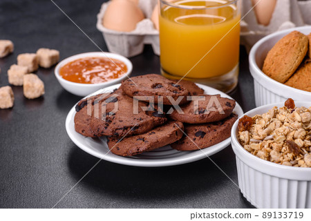 Delicious nutritious healthy breakfast with granola, eggs, oat cookies, milk and jam 89133719