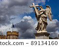 Marble statue of winged angel with a cross from the Ponte Sant'Angelo Bridge on the cloudy sky background. Rome, Italy. 89134160