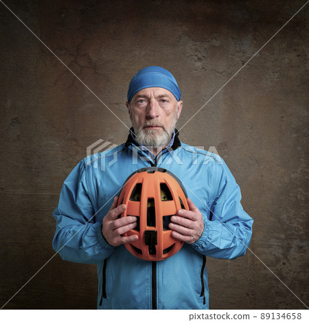 senior cyclist in bright blue biking jacket 89134658