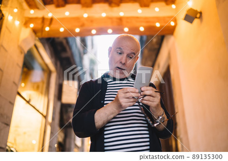 Amazed male blogger reading received email message with shock news about travel vacations, Amazed male blogger reading received email message with shock news about travel vacations, 89135300