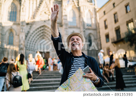 Cheerful Caucaisan man gesturing hand during solo vacations Cheerful Caucaisan man gesturing hand during solo vacations 89135393