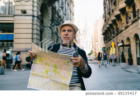Mature male senior 60s visiting city during getaway trip Mature male senior 60s visiting city during getaway trip 89135417