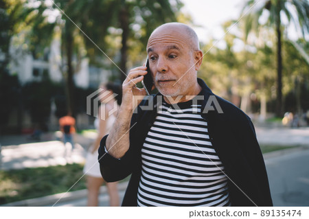 Amazed tourist talking during international smartphone conversation Amazed tourist talking during international smartphone conversation 89135474